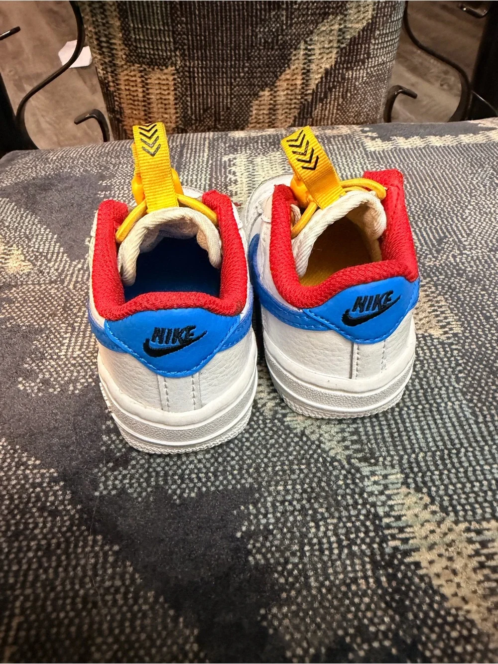 Nike White Kids Sneakers with Red Lining, Yellow Laces & Blue Accents